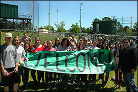 Secretary Pablos posing with students holding up a Welcome banner.