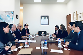 Secretary Hughs sitting at a table with other officials.