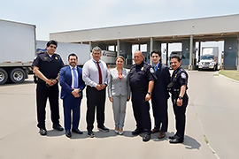 La secretaria y unas personas en frente de una puente. 